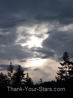 Sun behind Dark Clouds above Black Forest